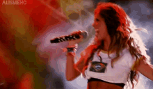 a woman is singing into a microphone with the word alismehc on the bottom