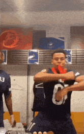 a man in a jersey with the number 13 on it is dancing in a locker room