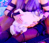 a woman is holding a pug dog in her lap