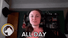 a woman wearing headphones says all day in front of a bookcase