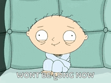 a cartoon character sitting on a couch with the words wont be long now