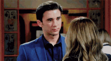 a man in a blue suit stands next to a woman