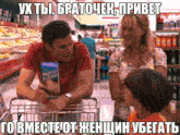 a man in a red shirt is pushing a shopping cart while a woman and child look on