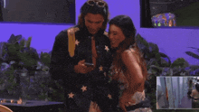 a man and a woman standing next to each other looking at a cell phone