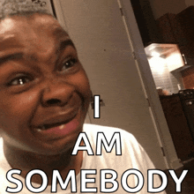a man making a funny face with the words " i am somebody " behind him