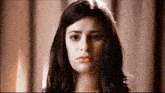 a close up of a woman 's face with a sad expression