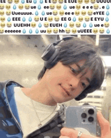 a man wearing headphones is taking a selfie with his cell phone .