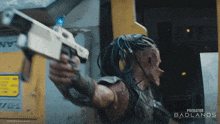 a movie poster for predator badlands shows a man with dreadlocks holding a gun