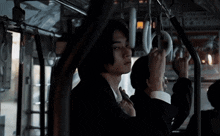 a man in a suit is holding onto a hand rail on a bus