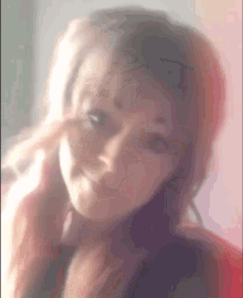 a blurry picture of a woman 's face with a pink background