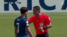 a soccer player wearing the number 7 talks to another player