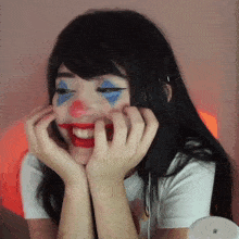 a woman with clown makeup on her face is smiling