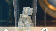 a glass filled with ice cubes is sitting on a table .