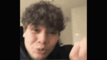 a close up of a person 's face with curly hair making a face .