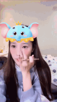 a woman wearing a blue elephant mask with a crown