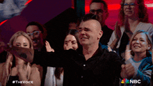 a group of people watching a show called the voice on nbc