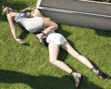 two women laying on the grass with one wearing a pair of black sandals that say prada