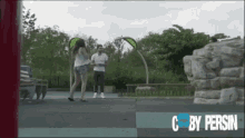 a man and a woman are standing in a park and the words c by persin are on the bottom