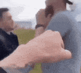 a man is holding another man 's hand while they are fighting .