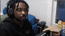 a man wearing headphones sits in front of a panatec computer monitor