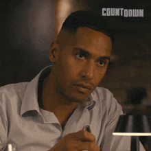 a man sitting at a table with the word countdown on the bottom right