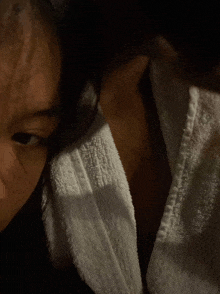 a close up of a person 's face with a towel around their neck