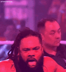 a man with dreadlocks and a beard is sitting in a ring with his eyes closed and his mouth open .