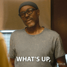 a man with glasses and a beanie says what 's up