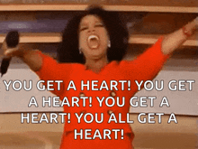 oprah winfrey is holding a microphone with her arms outstretched