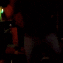 a blurry picture of a man in a dark room with blue lights behind him