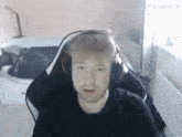 a man wearing headphones is sitting in a chair in front of a bathtub .