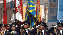 a group of men salute in front of a sign that says 70 met