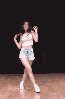 a woman in a crop top and shorts is dancing on a stage