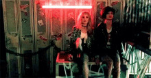 a couple of mannequins are sitting next to each other in a room with lockers .