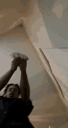 a man is holding a bunch of money in his hand