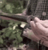 a person is holding a piece of metal in their hands and cutting it with a knife .