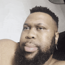 a man with a beard has a pair of earrings on his left ear