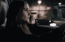 a woman talking on a cell phone while driving a car