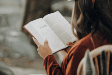a woman is reading a book with the word proverbs on the cover