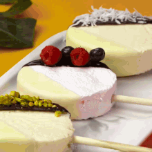 a white plate topped with ice cream cakes with berries on top