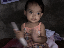 a little girl wearing a pink tank top with a cartoon character on it