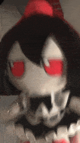 a stuffed doll with red eyes and a bow tie