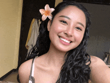 a woman smiles with a flower in her hair