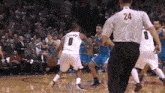 a basketball player with the number 8 on his back is dribbling the ball