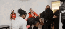 a group of people are standing in a room fighting .