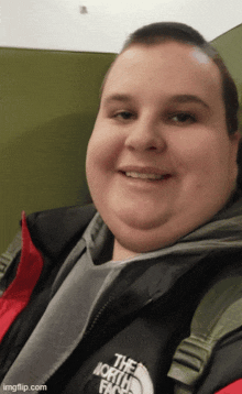 a smiling man wearing a north face jacket