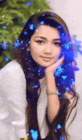 a woman 's face is surrounded by blue snowflakes and sparkles