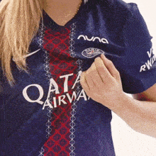 a woman is wearing a shirt that says qata airway on it
