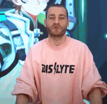a man wearing a pink shirt that says dis/lyte on it