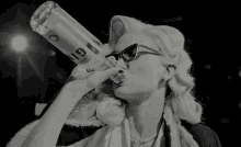 a woman drinking from a bottle that says gin on it